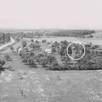 aerial view of a rural landscape with trees and farm buildings