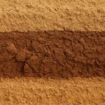 Close-up view of different layers of soil exhibiting variations in color and texture.